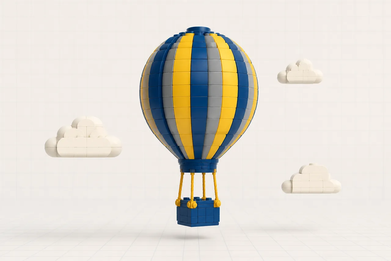 A plump hot-air balloon built from navy, yellow and grey striped toy bricks with a small basket, rising among a few soft brick clouds.